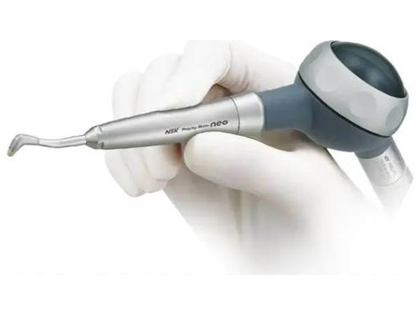 Наконечник AirFlow prophy-mate neo NSK в руке в белой перчатке